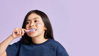 Adorable kid brushing teeth with Schmidt's Kids Toothpaste in Mint+Berry
